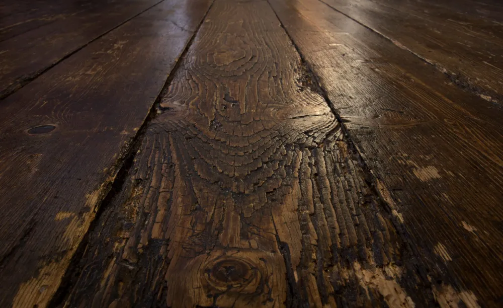 Scratched and worn hardwood floor in Uganda before sanding and refinishing
